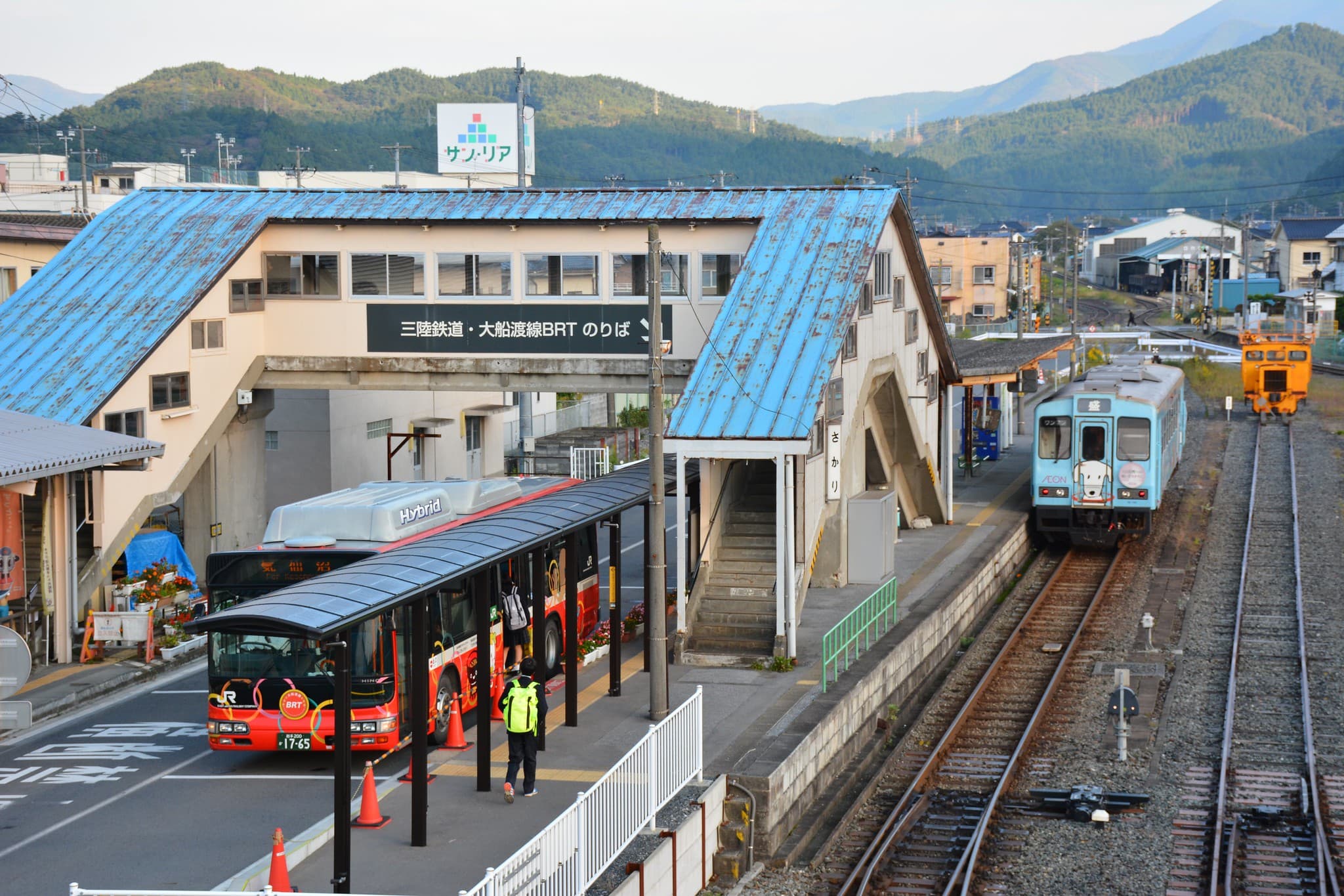 盛駅に停車するBRTバスと気動車